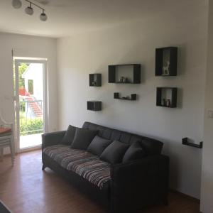 Sofá negro en una sala de estar con ventana en Vila Jovana, en Sutomore