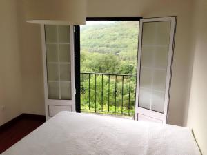 1 dormitorio con cama y ventana con vistas en Quinta Parque Nacional Peneda Geres en Paradamonte
