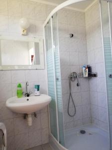 een badkamer met een wastafel en een douche bij Bartók Apartmanház in Balatonszárszó
