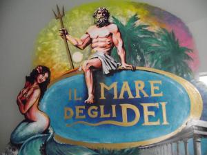 a painting of a man sitting on top of a sign at B&B Il Mare degli Dei in Letojanni