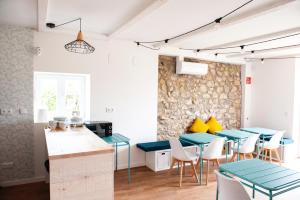 a kitchen and dining room with blue tables and yellow pillows at La Casita de Melón in Suances