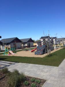 a park with a playground with a slide at Domki Wśród Jabłoni in Gąski