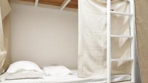 Cong Sen Backpackers Hostel في مدينة تايتونج: سرير بطابقين أبيض مع سلم في الغرفة