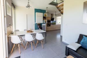 a kitchen and living room with a table and chairs at La maison des gardiens de l'Océan & spa - Les Gîte de Fabie - Plougonvelin in Plougonvelin
