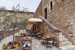 un patio con tavoli e sedie accanto a un edificio di Locanda Il Porcellum a Bagno Vignoni