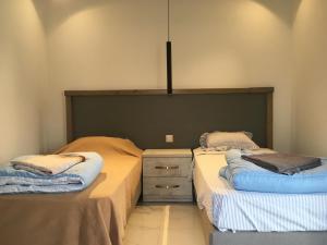 two twin beds in a bedroom with a dresser and awered at Seaside Room in Msida