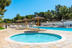 a swimming pool with chairs and umbrellas at Salou Pacific Rentalmar in Salou