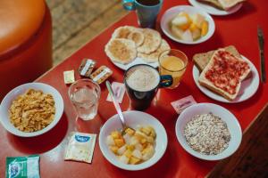 una mesa roja cubierta con tazones de alimentos para el desayuno en Clink78 Hostel, en Londres