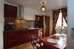 a kitchen with a table with a red table cloth on it at RIBEAUVILLE city center - Gîte des Ménétriers, LE TOKAY - in Ribeauvillé