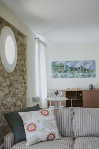 un soggiorno con divano e parete in pietra di Ca Muretta Relais a Bardolino