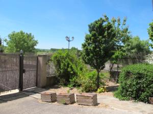 uma cerca com caixas de madeira ao lado de uma árvore em El Eresma de Carmen em Hontanares de Eresma