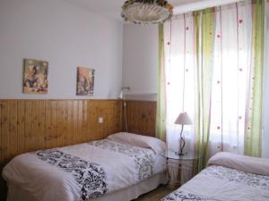 1 Schlafzimmer mit 2 Betten, einer Lampe und einem Fenster in der Unterkunft El Eresma de Carmen in Hontanares de Eresma