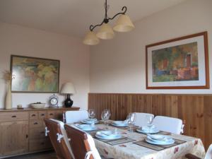 ein Esszimmer mit einem Tisch mit Stühlen und einem Gemälde in der Unterkunft El Eresma de Carmen in Hontanares de Eresma