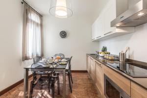 a kitchen with a table and chairs in a room at Ca' Del Monastero 5 Collection Cosy Apartment for 4 Guests in Venice