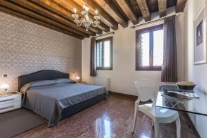 Ca' Del Monastero 3 Collection Apartment for 4 Guests with Lift في البندقية: غرفة نوم بسرير ومكتب ونوافذ
