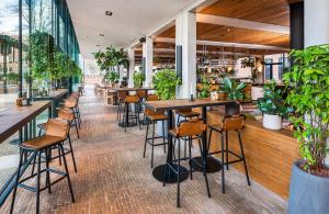 a restaurant with tables and chairs and plants at Hotel Arena in Amsterdam +62 photos