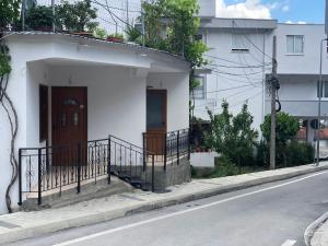 a white house on the side of a street at Room Click inn in Gjirokastër