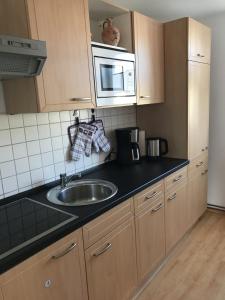 a kitchen with a sink and a microwave at Pensione da Vito in Greifswald