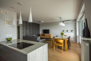 uma cozinha e sala de estar com uma mesa e um sofá em Easy Apartments Kielce em Kielce