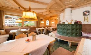 a restaurant with tables and chairs and a chandelier at Tanneck Garni in Berwang