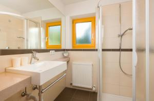 a bathroom with a sink and a shower at Tanneck Garni in Berwang