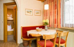 a dining room with a table and chairs and a bed at Tanneck Garni in Berwang +33 photos