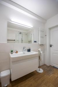 a white bathroom with a sink and a toilet at Easy Apartments Kielce in Kielce