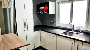 a kitchen with white cabinets and a sink and a window at Paseo de La Victoria in Córdoba +21 photos