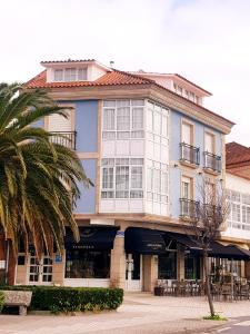 un edificio azul y blanco con una palmera en Ribeira de Fefiñanes en Cambados