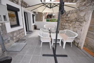 einen Tisch und Stühle mit Sonnenschirm auf einer Terrasse in der Unterkunft House by The Sea in Tivat