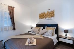 una camera da letto con un letto grande con un vassoio sopra di Apartments Nana a Podstrana