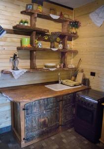 a kitchen with a wooden counter and a stove at Căsuța din Povești - Vatra in Vatra Dornei