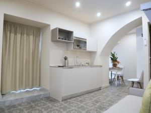 uma cozinha com um lavatório e um balcão num quarto em Vuciata Apartments em Catânia