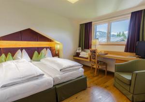 una camera d'albergo con un letto grande e una scrivania di Hotel Kaprunerhof a Kaprun