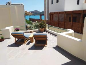 a patio with two chairs and a table on a building at Christina Boutique Studios Elounda in Elounda