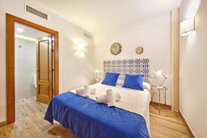 a bedroom with a blue and white bed with blue pillows at Palma Old Town - Turismo de Interior in Palma de Mallorca +18 photos