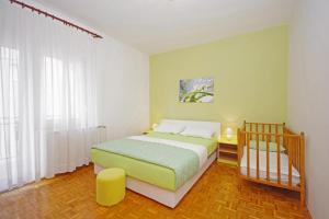 a bedroom with a bed and a crib at Marija Apartments in Pirovac