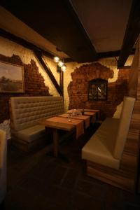 a dining room with tables and chairs and a brick wall at Motel Vila Bakarni in Brčko