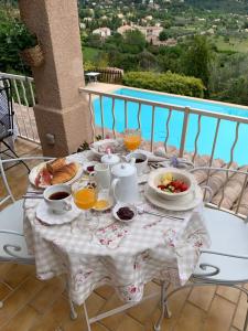 een tafel met ontbijtproducten en drankjes op een balkon bij Villa Magnolia in Seillans