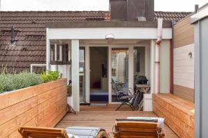 a backyard patio with chairs and a wooden fence at Rooftop Penthouse Karlsruhe in Karlsruhe