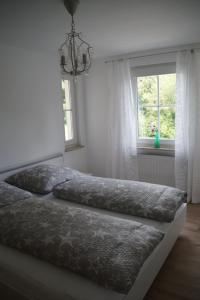 מיטה או מיטות בחדר ב-Ferienwohnung am Bodensee Wintergarten und Garten mit Grillhaus