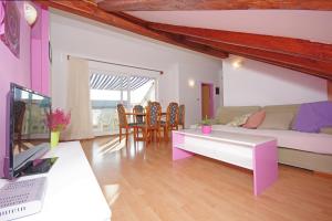 a living room with a couch and a table at Marija Apartments in Pirovac