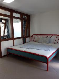 a bed sitting in a room with two windows at lOKALBOARDEN in Elsendorf