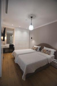 een slaapkamer met een groot wit bed en een bureau bij Boutique Hotel Whisky in Tirana