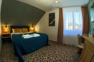 um quarto de hotel com uma cama e uma janela em Residence Rooms Bucovina em Câmpulung Moldovenesc