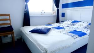 Una cama con sábanas azules y blancas y una ventana en Apartament Il Capitano, en Gdynia