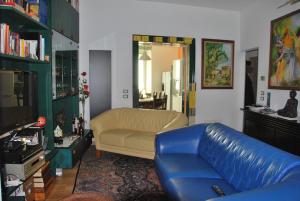 a living room with a blue leather couch and a television at B&B Percorso Verde in Ponte Valleceppi
