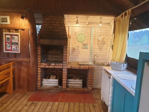 a kitchen with a brick fireplace in a house at Domek Wieloosobowy - Agroturystyka in Przetycz
