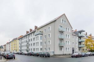a large building with cars parked in a parking lot at Private Apartment in Hannover