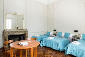a room with two beds and a table and a mirror at Patios de Recoleta in Buenos Aires